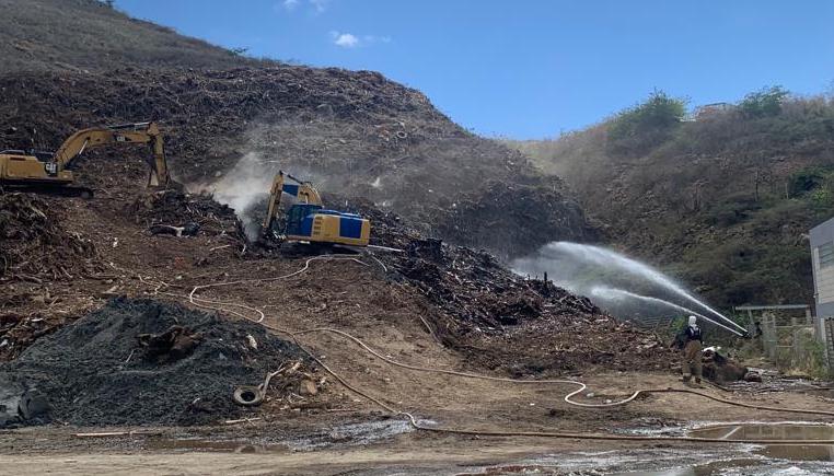 Firefighters employ hoses and heavy equipment to battle a fire at the Bovoni landfill Monday on St. Thomas. (Photo courtesy V.I. Fire and Emergency Medical Services)
