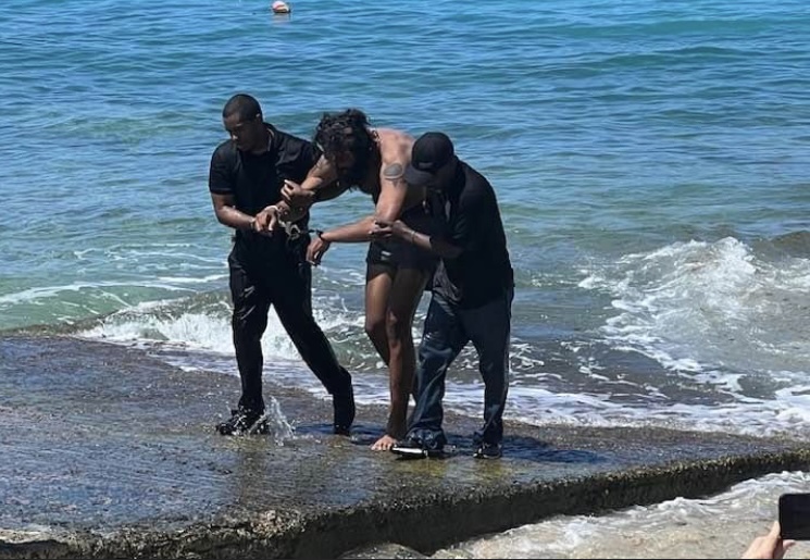 Homicide suspect Mohammed Salem is led in handcuffs up the boat ramp at Hull Bay on St. Thomas after a manhunt Tuesday. (VIPD photo)
