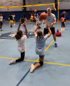 Gold medalist Renan dal Zotto works on setting a basketball with Chloe Irons and Seava Brin at volleyball camp. (Source photo by Mark J. Daniel)