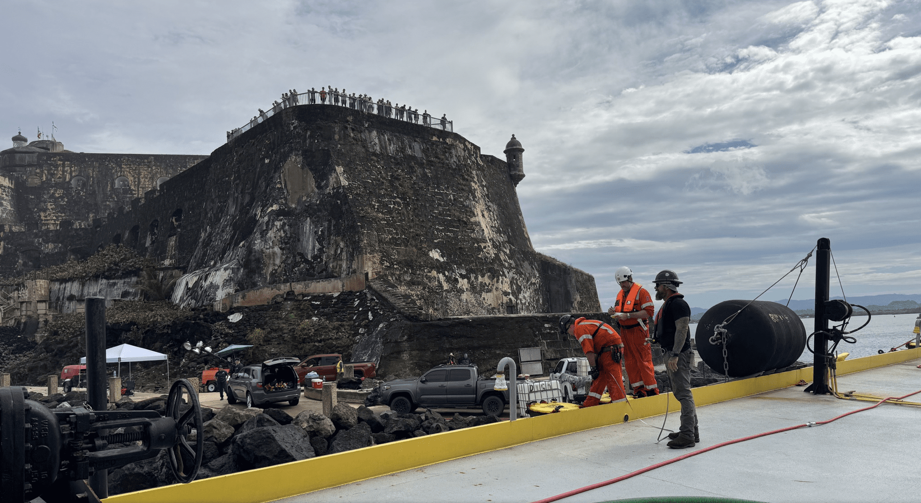 Workers remove fuel from the barge Defiant on Thursday after it grounded off el San Felipe del Morro Castle in San Juan, Puerto Rico. (Photo courtesy Coast Guard)